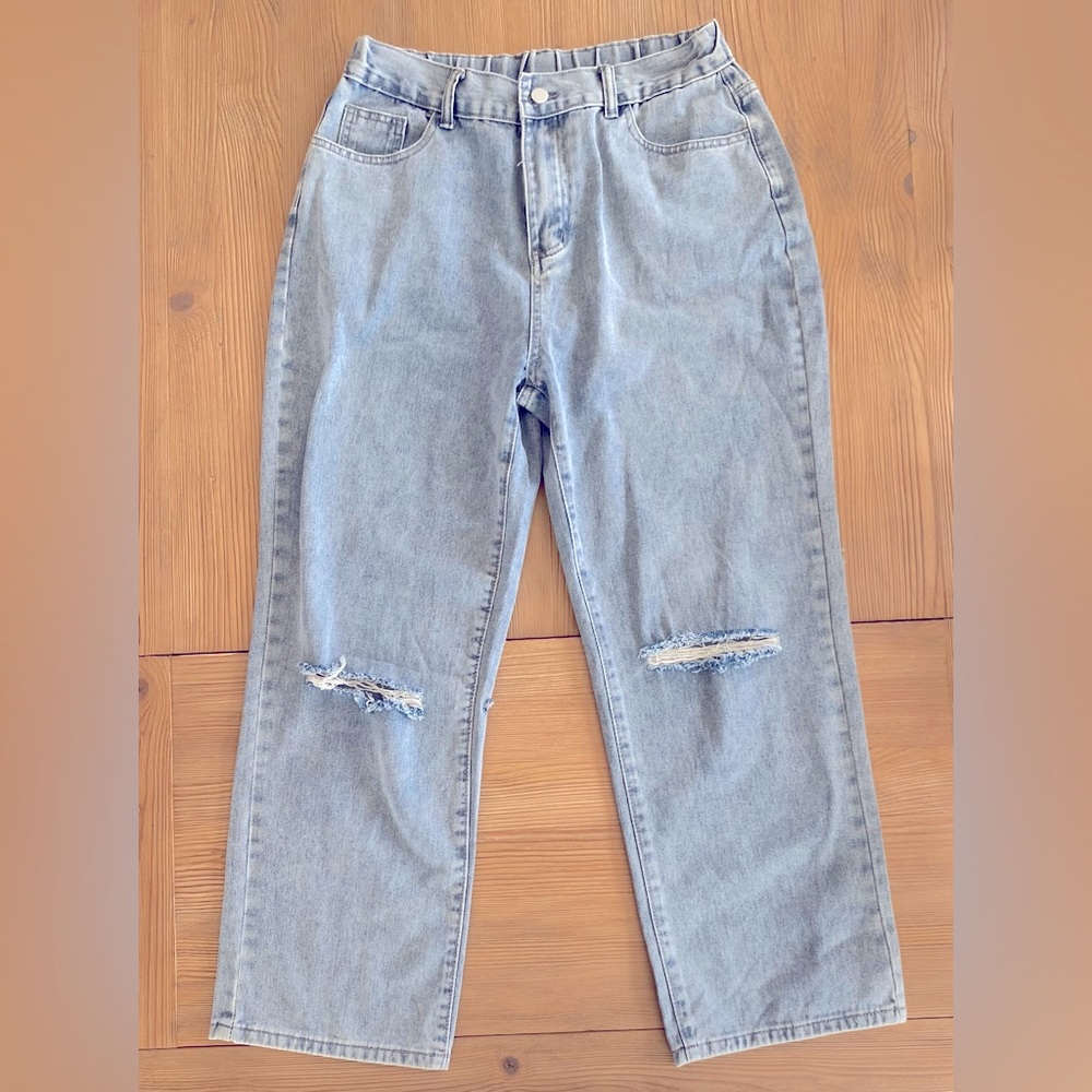 Large Women’s jeans with ripped knees and elastic back waist.